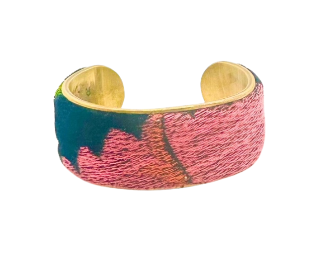 The 2-inch France cuff bracelet showcases an embroidered velvet overlay with colorful floral patterns in pink, red, and green. Crafted on a durable vintage brass base by Redd Dott Jewelry.