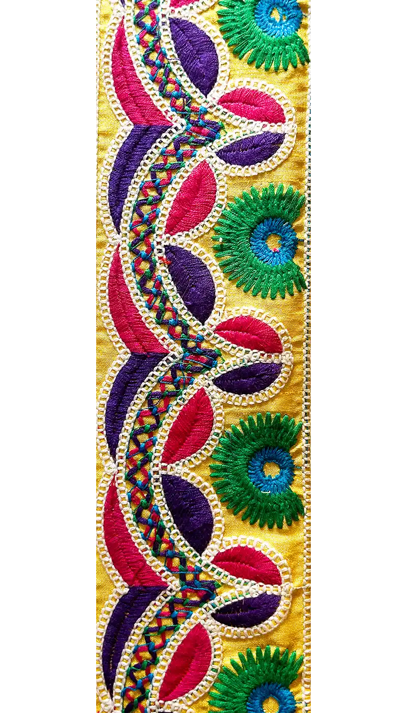 Close-up of bright yellow embroidered textile cuff bracelet fabric with pink, purple, and green floral threads, handcrafted in Shreveport, LA by Redd Dott Jewelry.