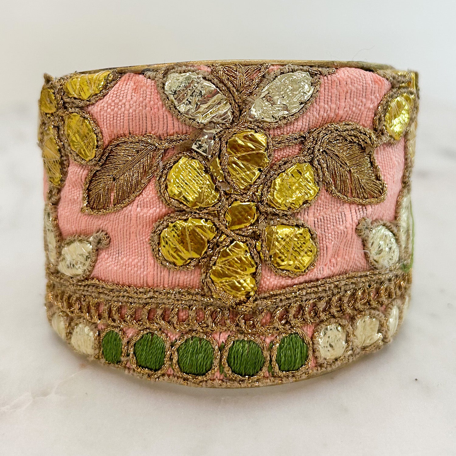 Close-up of Amelia Cuff Bracelet showing golden embroidered florals and green accents on soft pink vintage fabric, handcrafted in Shreveport, LA by Redd Dott Jewelry.