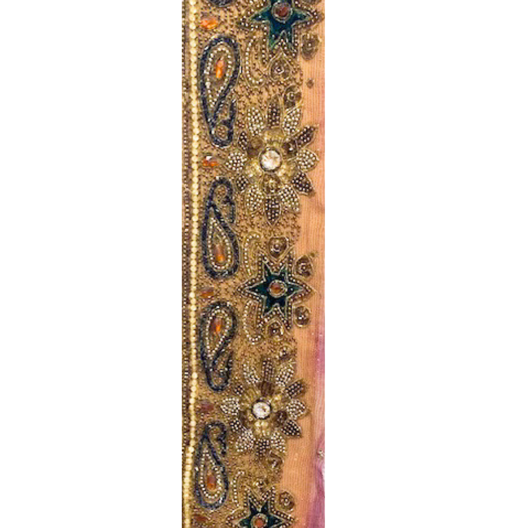 A vintage cuff bracelet by Redd Dott Jewelry, featuring intricate gold floral and paisley beadwork, emerald star motifs, and shimmering crystal accents.