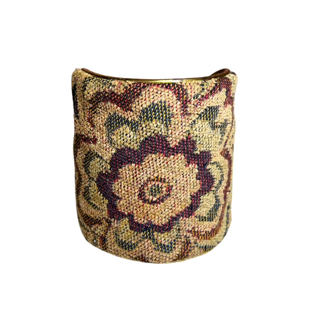 A handcrafted brass cuff bracelet by Redd Dott Jewelry featuring vintage tapestry fabric with a floral motif in burgundy, green, and beige. A richly woven vintage brass bracelet with antique charm.