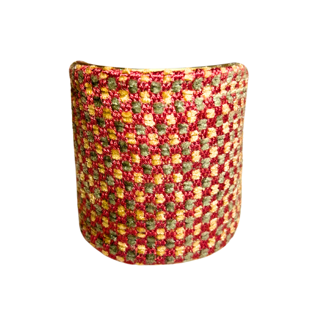A handmade brass cuff bracelet from Redd Dott Jewelry, crafted and stamped in Shreveport, LA. Features a raised red, gold, and olive green checkered pattern with a rustic cuff bracelet feel over a vintage brass base.
