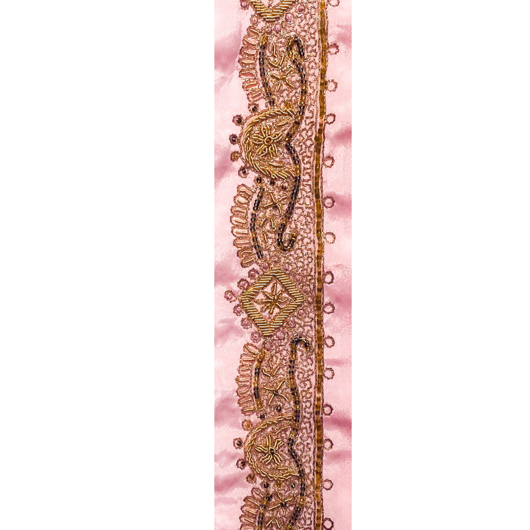 A Rustic Cuff Bracelet by Redd Dott Jewelry, featuring intricate golden embroidery-like details over a soft blush-toned background.