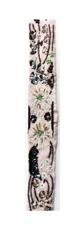 Floral embroidered cuff bracelet featuring intricate beadwork and sequin flowers in ivory, black, and green on a blush background, creating a delicate and elegant design.