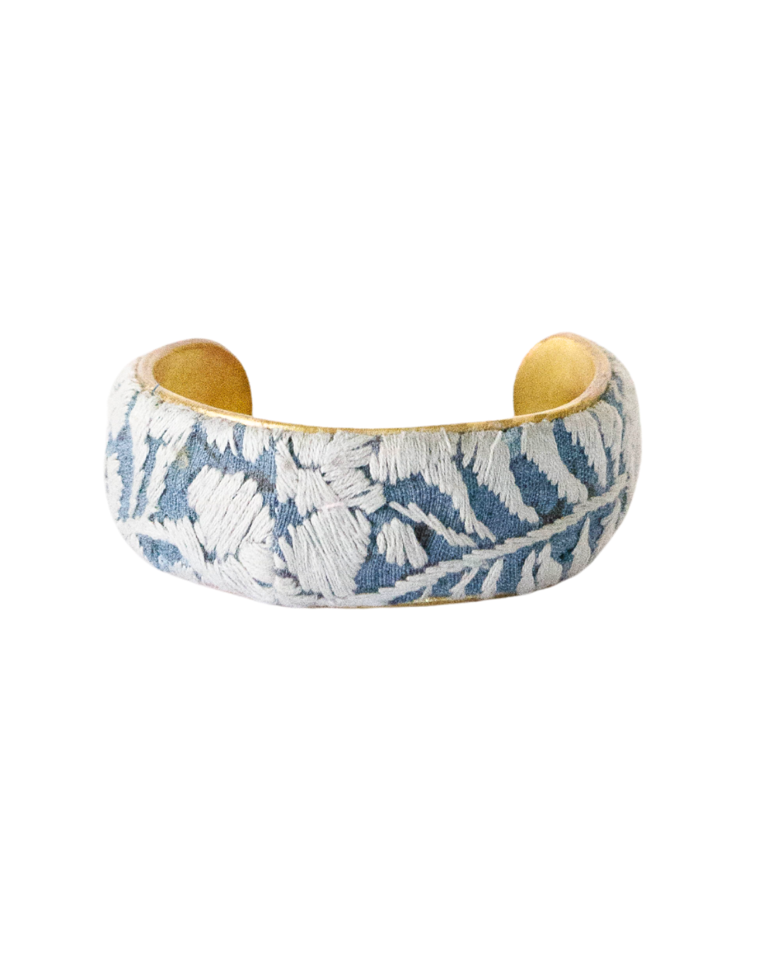 One-inch Cielo Gris embroidered brass cuff bracelet with ivory floral stitching on a pale blue base.