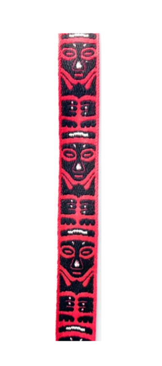 African-inspired hand-stamped cuff bracelet featuring bold red and black tribal face patterns, highlighting traditional designs and craftsmanship.