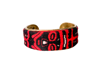 African-inspired jewelry cuff bracelet from Redd Dott Jewelry featuring bold red and black tribal patterns on a brass base, showcasing a striking and culturally rich design.