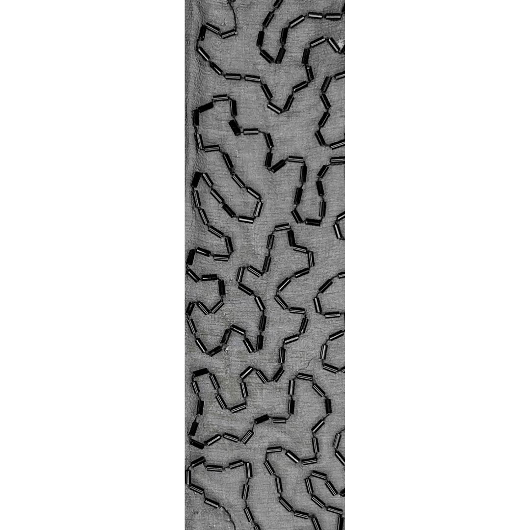 A ladies cuff bracelet by Redd Dott Jewelry, featuring an abstract black beaded pattern on a smoky gray fabric base.