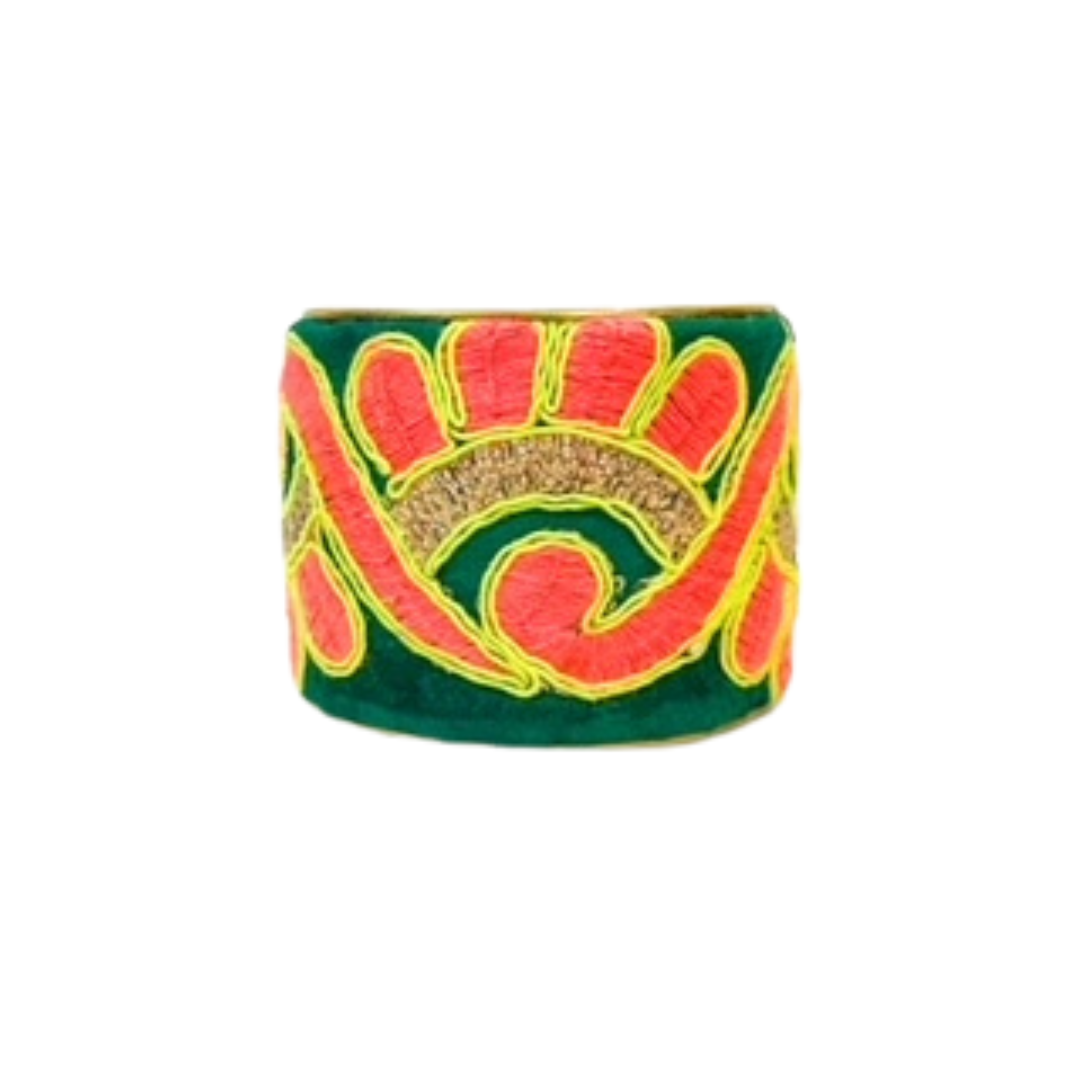 A studio image of a 2-inch brass cuff bracelet for women wrapped in emerald-green fabric with bold coral and sunshine-yellow embroidery; one of a kind jewelry with a smooth, adjustable open-back fit.