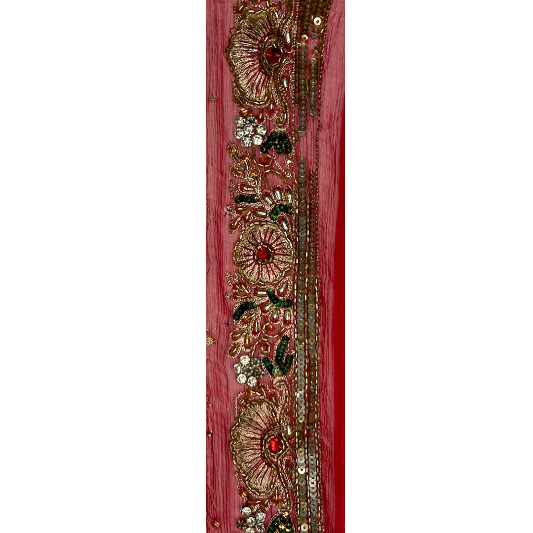 A beaded flower bracelet by Redd Dott Jewelry, featuring intricate gold embroidery, red and green beaded floral designs, and shimmering sequins on a deep rose-red fabric.