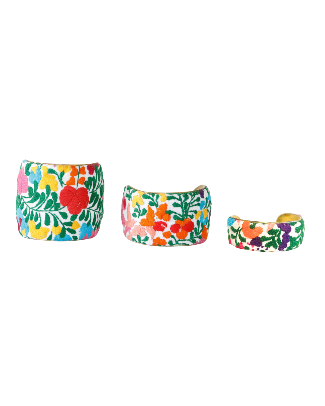 Trio of Fiesta Viva brass cuff bracelets in 1”, 2”, and 3” widths, embroidered with vibrant Mexican floral patterns in red, orange, yellow, blue, and green on white fabric.