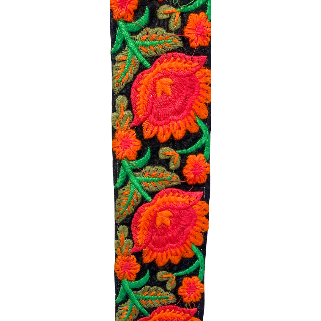 Nature-inspired jewelry cuff bracelet by Redd Dott Jewelry, featuring a black fabric base with bold orange and red floral embroidery, green leaf detailing, and a hand-stamped personalized message inside.