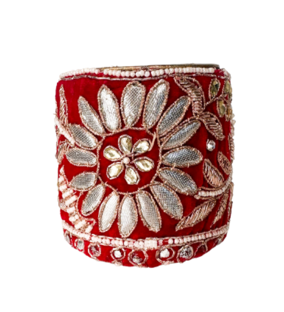 Red and silver beaded cuff bracelet featuring intricate floral embroidery with silver beads and metallic threads on a vibrant red fabric, creating a bold and luxurious design.