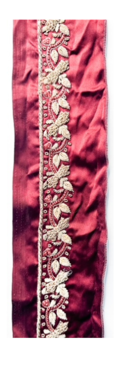 Delicate floral red silk cuff bracelet featuring intricate gold embroidery along a rich red silk fabric, showcasing an elegant and refined floral design.