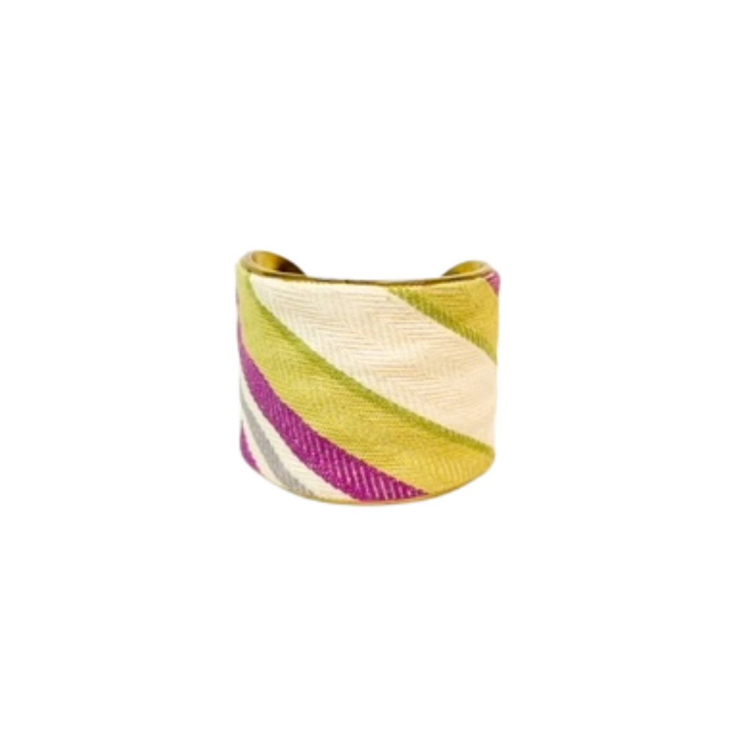 A studio image of a one of a kind jewelry brass cuff bracelet for women—a 2-inch wide, open-back design shown at an angle, wrapped in handwoven diagonal stripes of fuchsia, lime green, gray, and ivory, displayed on a white background.