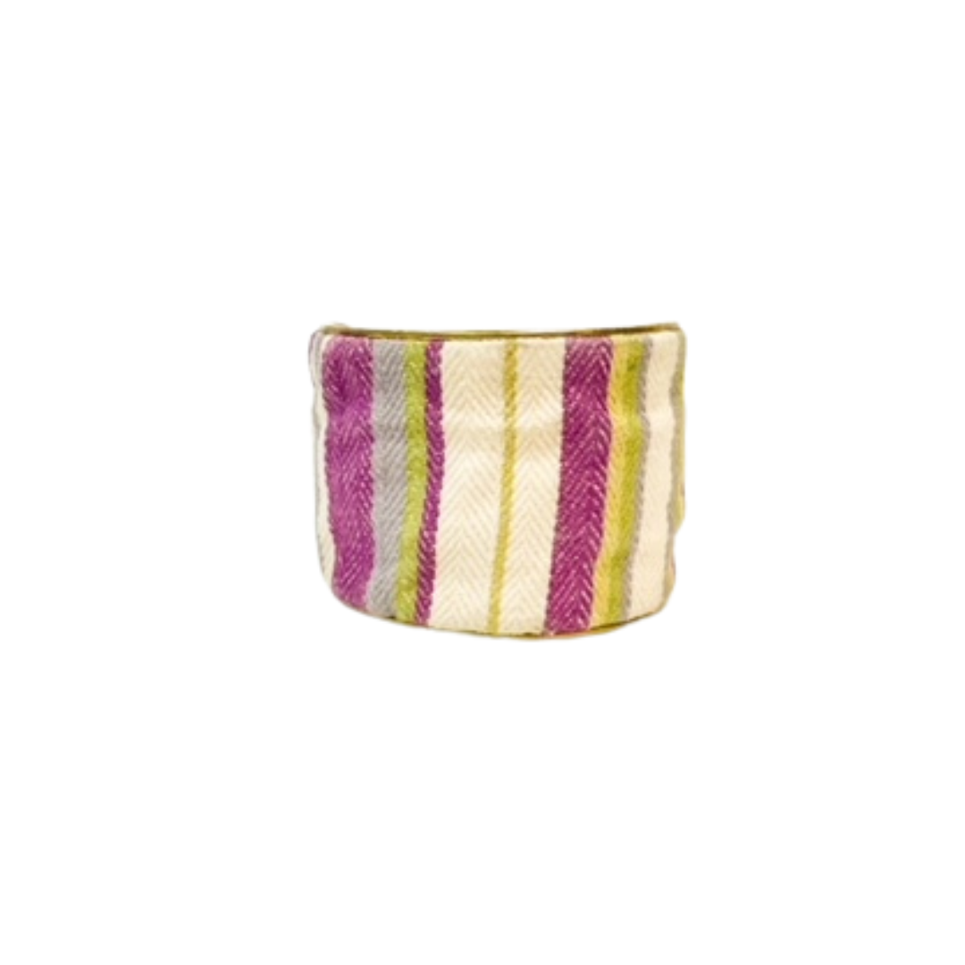 A studio image of a one of a kind jewelry brass cuff bracelet for women—a 2-inch wide, open-back design wrapped in handwoven diagonal stripes of fuchsia, lime green, gray, and ivory, shown straight on against a white background
