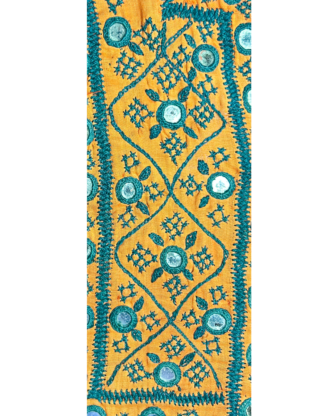 A handcrafted custom stamped cuff bracelet by Redd Dott Jewelry featuring teal floral embroidery and mirror accents on golden fabric. A bold, textural rustic cuff bracelet and vibrant piece of embroidered jewelry.