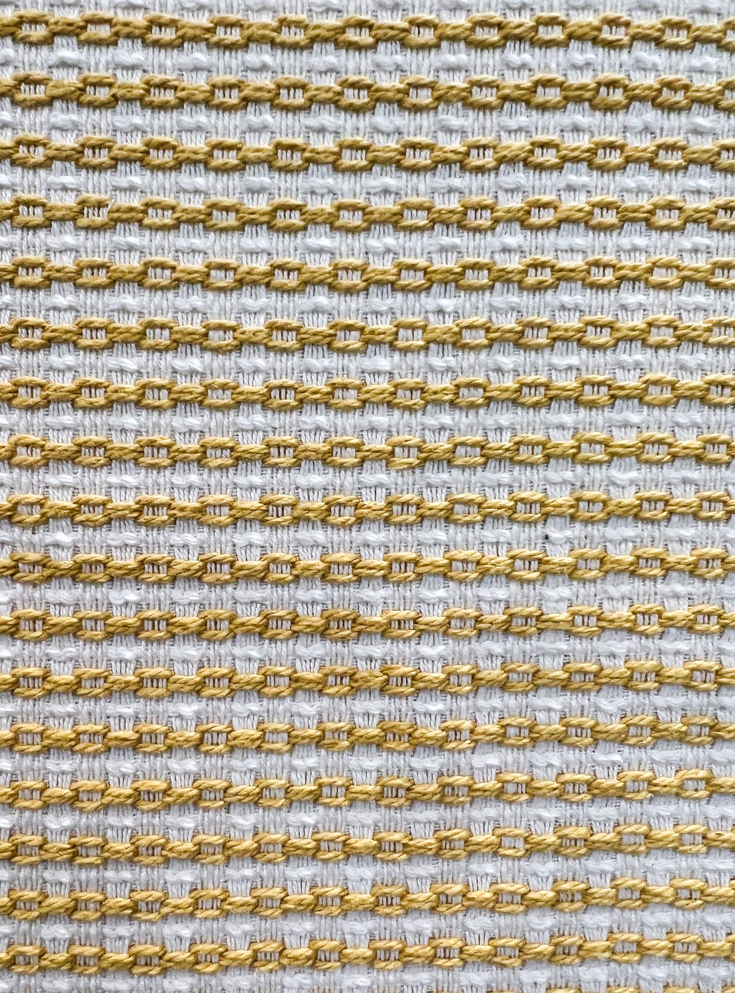 Close-up of Kyleigh cuff bracelet fabric – yellow and white woven chain-like embroidery in a soft textured pattern, used for handcrafted custom brass cuff jewelry.