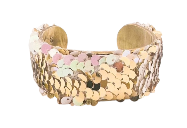 The Let Them Eat Cake cuff bracelet by Redd Dott Jewelry showcases gold sequins with soft pink hues on a vintage brass base. Available in 1-inch, 2-inch, and 3-inch sizes with a hand-stamped message inside.