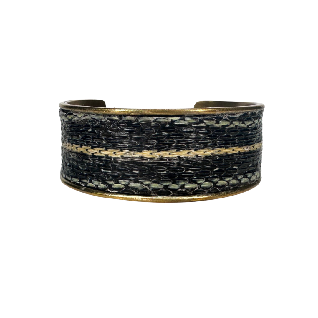 Close-up of handcrafted rustic cuff bracelet made from genuine garter snake skin in black and tan tones on a gold cuff bracelet base, handcrafted in Shreveport, LA by Redd Dott Jewelry.