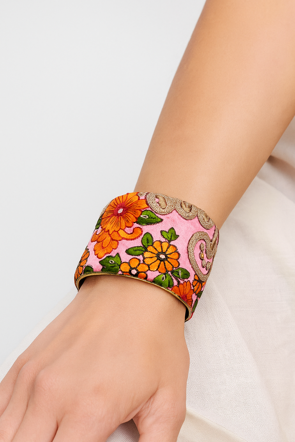 Woman wearing the Angelina Custom Stamped Cuff Bracelet featuring hot pink embroidered fabric with coral flowers and gold trim, handcrafted in Shreveport, LA by Redd Dott Jewelry.