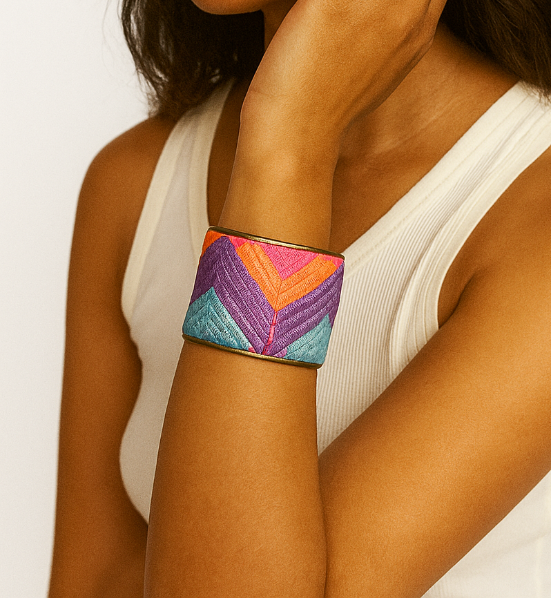 Woman wearing the Alice Custom Stamped Cuff Bracelet, a colorful embroidered brass bracelet with chevron design in pinke, blue, and purple. handcrafted in Shreveport, LA by Redd Dott Jewelry.
