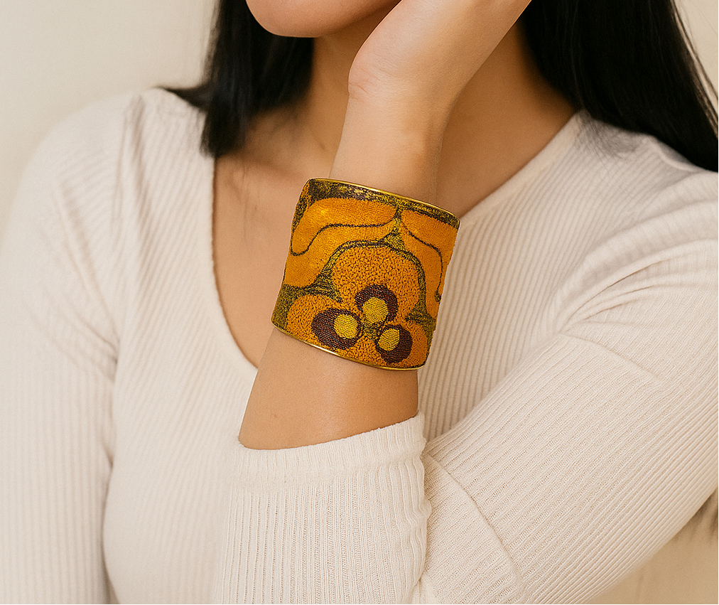 Woman wearing the Arina Brass Cuff Bracelet with amber and maroon embroidery on vintage fabric, handcrafted in Shreveport, LA by Redd Dott Jewelry.