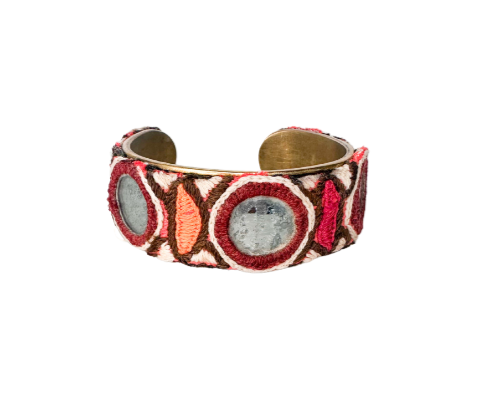 Colorful bohemian cuff bracelet with intricate embroidery, featuring a central mirror and sequin accents, surrounded by vibrant geometric patterns in earthy tones.