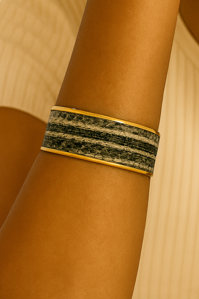 Close-up of a model wearing the Nomad Men’s 1-Inch cuff bracelet, featuring genuine garter snake skin with natural gray and charcoal striping set into a slim brass cuff, highlighting the rugged texture and handcrafted jewelry detail, handcrafted in Shreveport, LA by Redd Dott Jewelry.