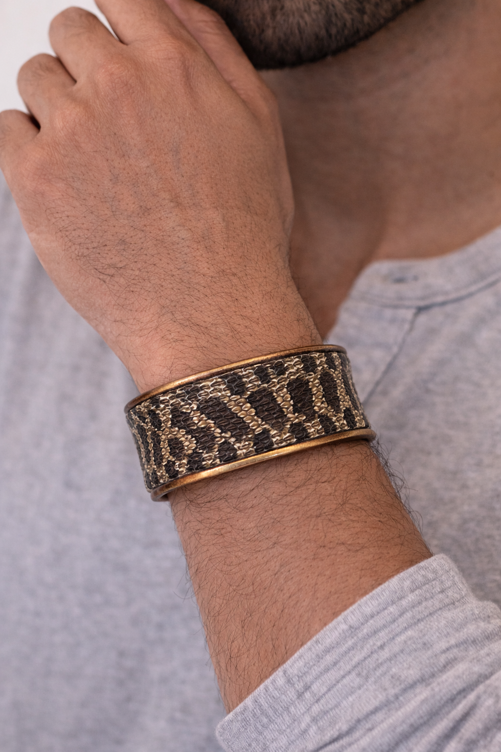 Man wearing a hognose snakeskin cuff bracelet with brass base, men’s statement jewelry handcrafted in Shreveport, LA by Redd Dott Jewelry.