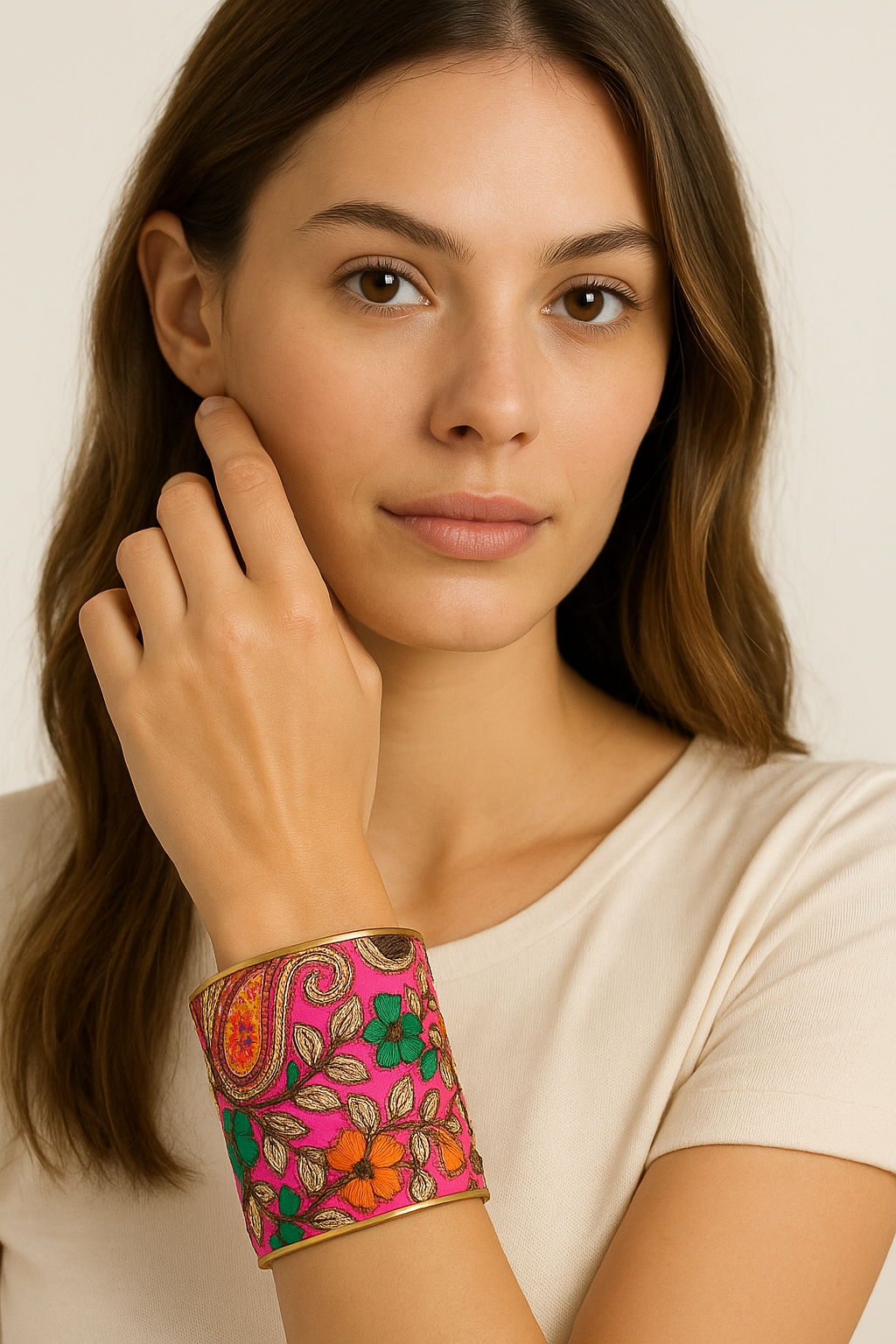 Model wearing the Redd Dott Olivia 3-inch cuff bracelet showcasing a vivid pink base with intricate embroidered paisley and floral patterns in orange, green, teal, and gold, framed with a metallic edge for a bold and artistic statement.