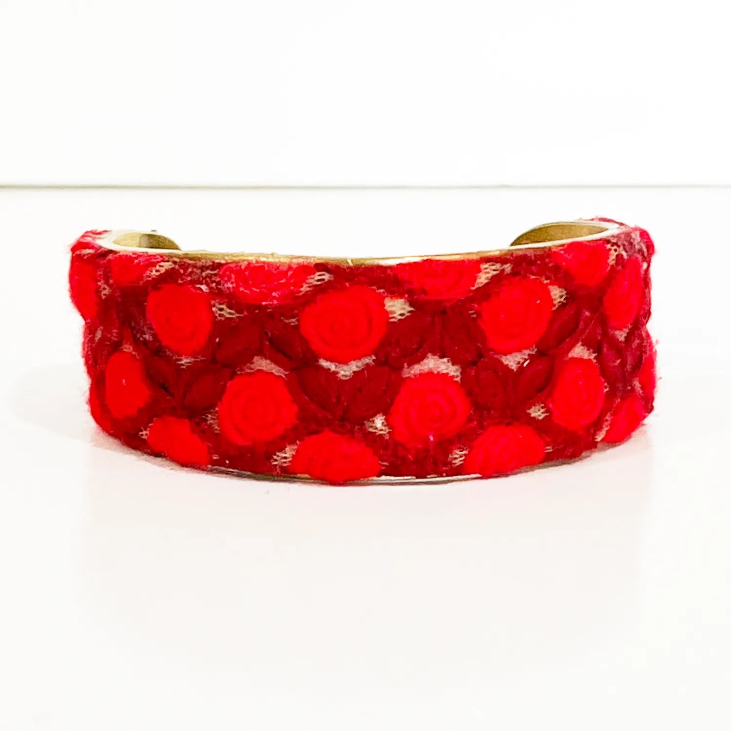 Red velvet cuff bracelet featuring raised flower petal designs in a vibrant red hue, creating a textured and luxurious accessory.