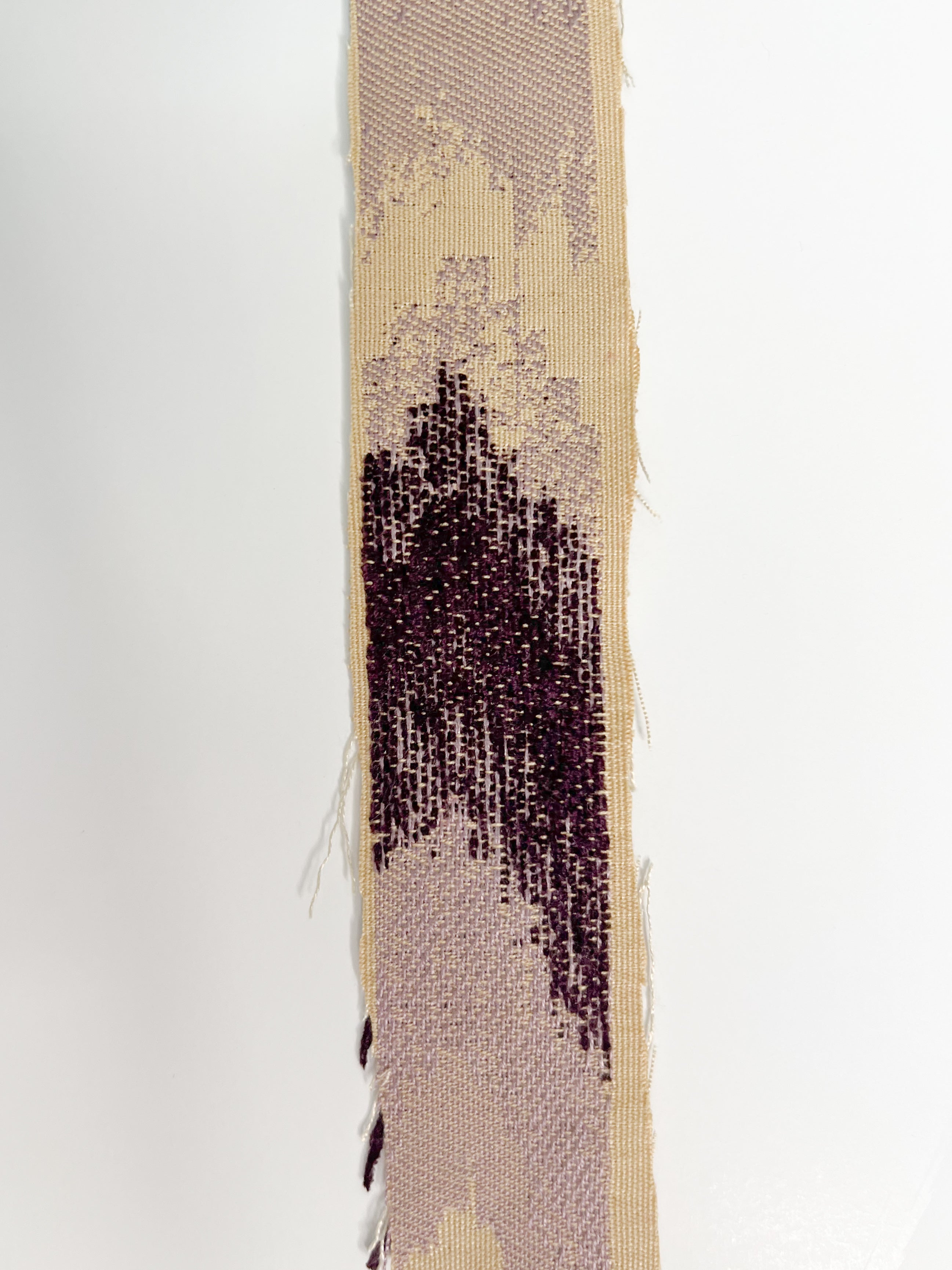 Close-up of Wisteria cuff bracelet fabric – textured woven base in cream with freeform gradient embroidery in soft lavender and deep plum purple, designed for a custom stamped brass cuff.