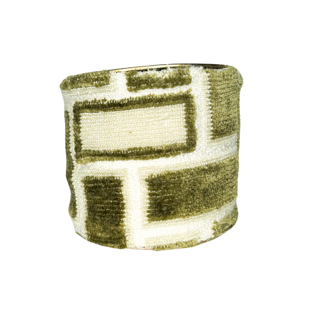 A wide brass cuff bracelet by Redd Dott Jewelry wrapped in a soft, textured fur bracelet fabric featuring a moss green and cream block pattern with a raised, velvety finish.