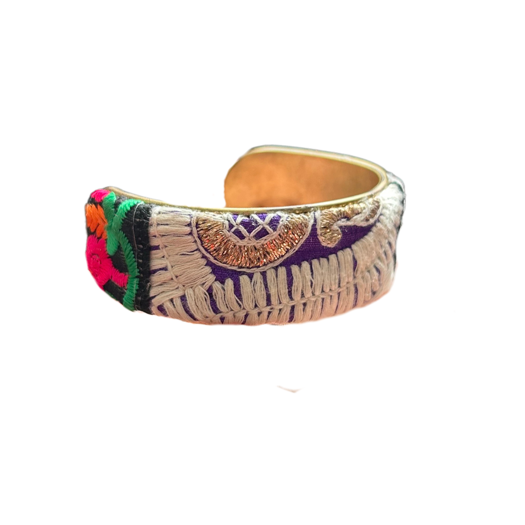 Ashari embroidered cuff bracelet – 1-inch brass cuff with cream fringe, purple and gold embroidery, and bold red and green accents, handcrafted by Redd Dott Jewelry.