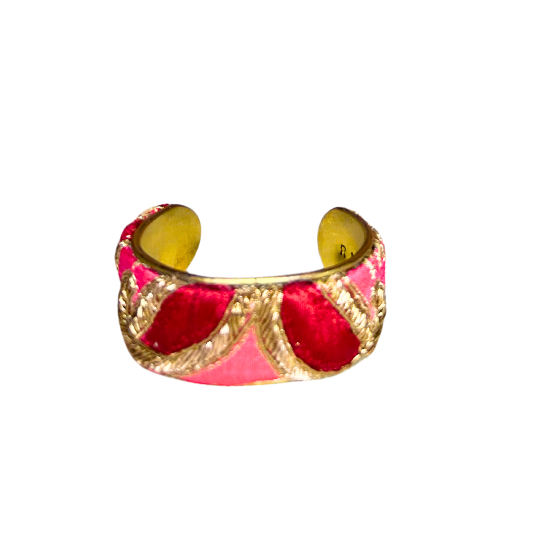 A handcrafted brass cuff bracelet by Redd Dott Jewelry with shimmering gold threadwork over hot pink textile. An eye-catching hot pink bracelet full of texture and detail.