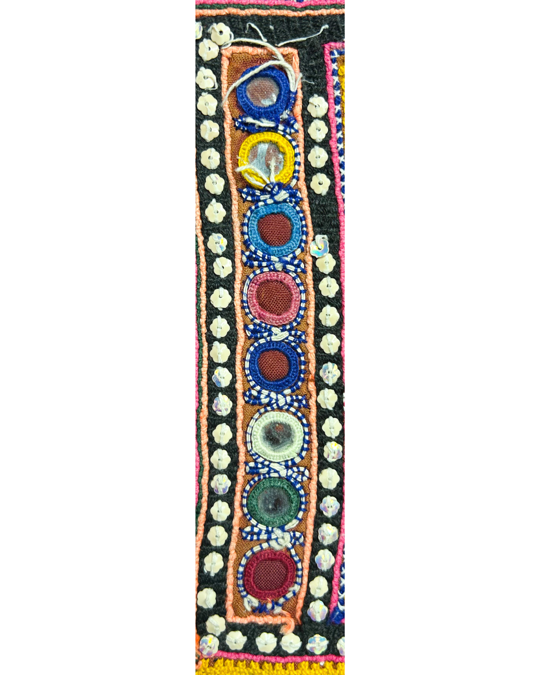 A handcrafted custom stamped cuff bracelet by Redd Dott Jewelry made with detailed kaftan fabric featuring embroidered circles, mirrors, and colorful borders. A bold, textured ladies cuff bracelet and vibrant piece of embroidered jewelry.