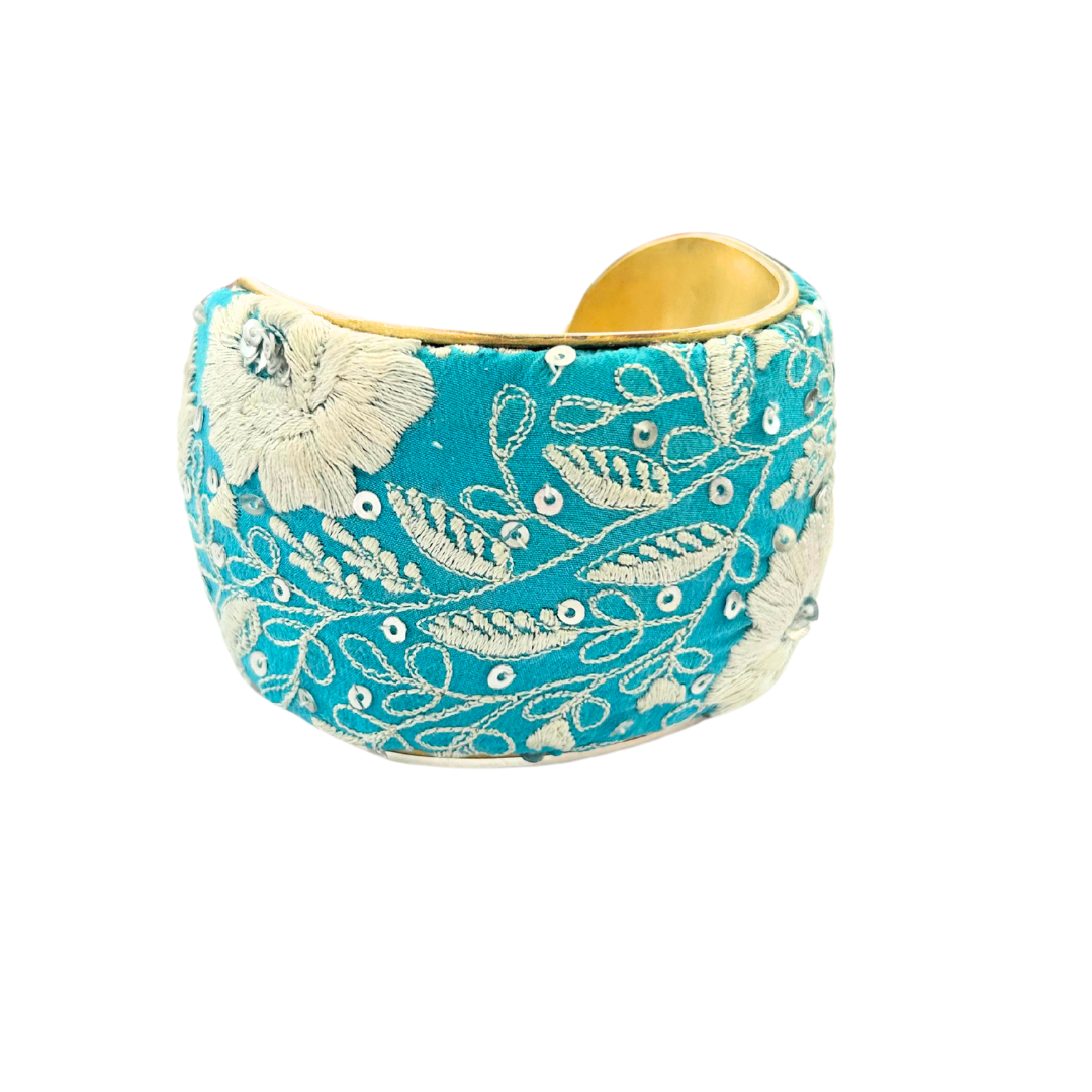 Casper cuff bracelet – teal vintage fabric with ivory floral embroidery, sequins, and vines on a wide brass cuff, handmade by Redd Dott Jewelry.
