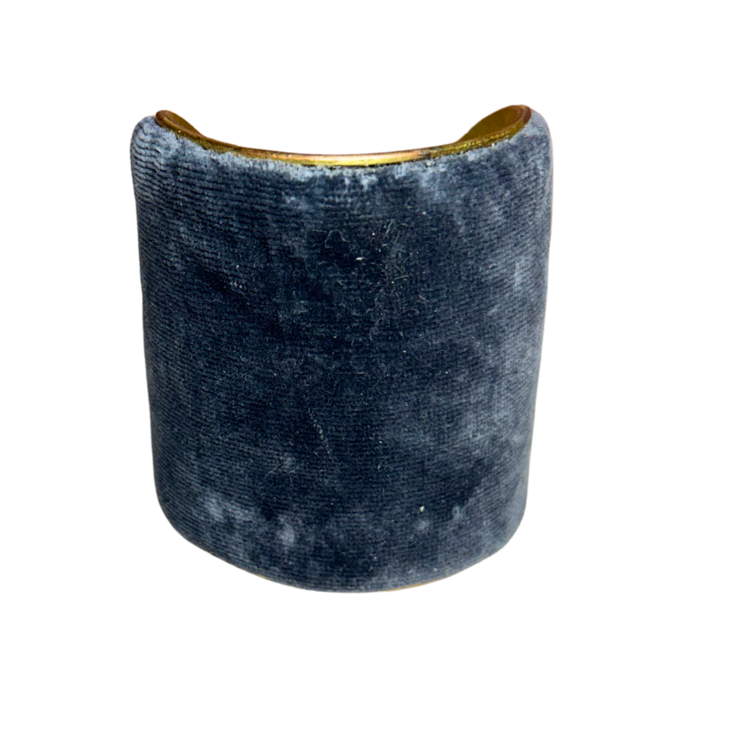 A handmade brass cuff bracelet, crafted and stamped in Shreveport, LA. Features a wide silhouette wrapped in deep blue-gray velvet with a soft texture, creating a muted and elegant rustic cuff bracelet look.