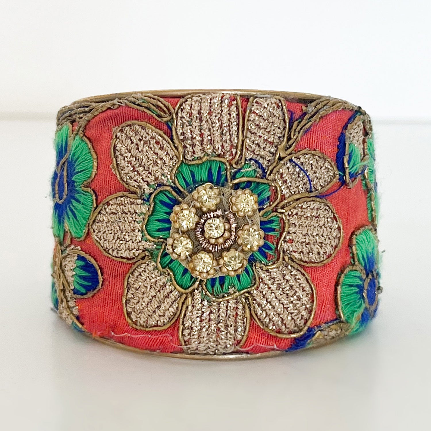 Bright floral embroidered brass cuff bracelet with gold-thread petals and a central raised flower detail. Nature inspired jewelry handmade by Redd Dott Jewelry in Shreveport, LA.