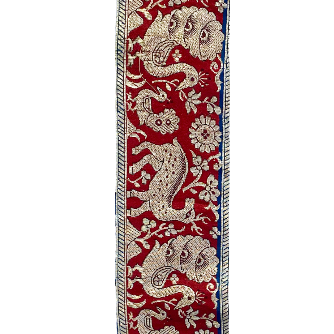 A statement cuff bracelet by Redd Dott Jewelry, handcrafted in Shreveport, LA. This customizable piece features an intricate stamped design of mythical creatures and florals, set against a bold red background with metallic detailing for a striking, timeless look.