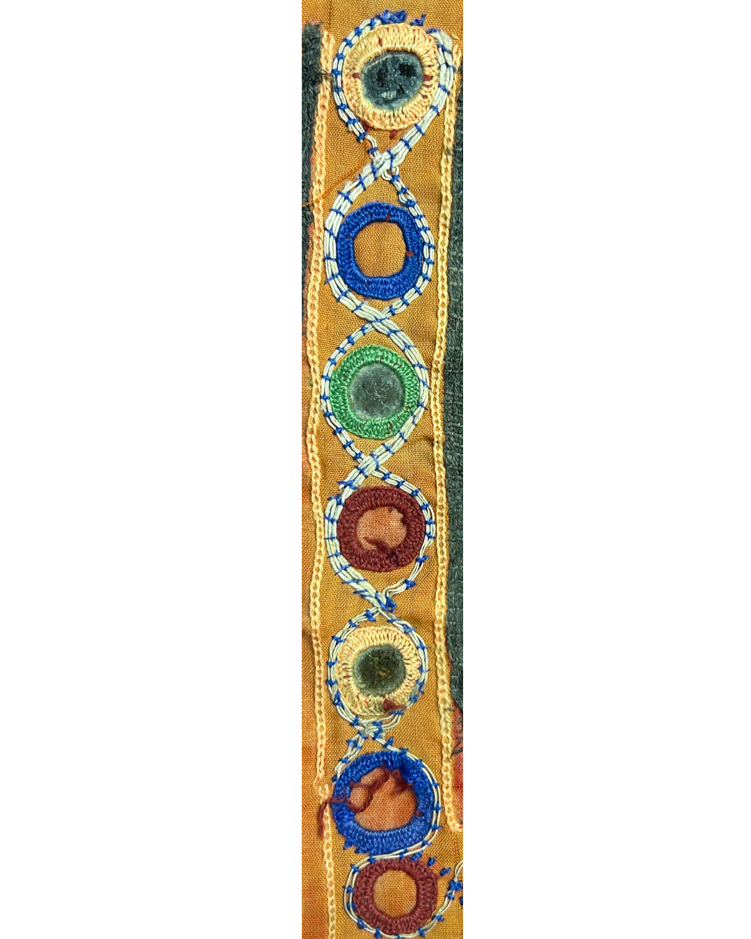 A handcrafted custom stamped cuff bracelet by Redd Dott Jewelry featuring embroidered kaftan fabric with circular stitching and mirrored details. A colorful, one-of-a-kind vintage brass bracelet.