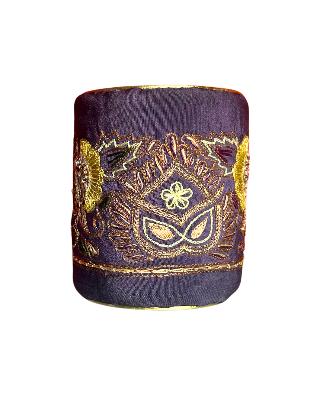 A handmade brass cuff bracelet from Redd Dott Jewelry, crafted and stamped in Shreveport, LA. Features deep purple silk fabric with gold and multicolor embroidery forming a mask and sunburst motif — a radiant ladies cuff bracelet and standout piece of embroidered jewelry.