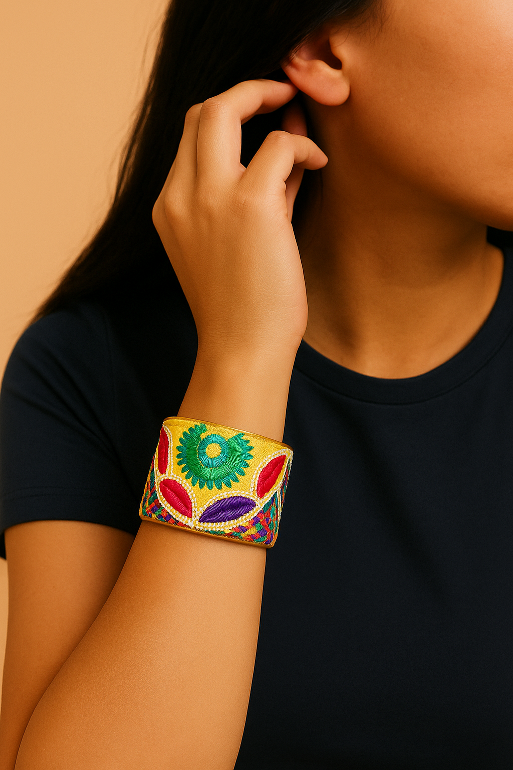 Woman wearing a bright yellow handmade brass cuff bracelet with fuchsia and green embroidered details, handcrafted in Shreveport, LA by Redd Dott Jewelry.