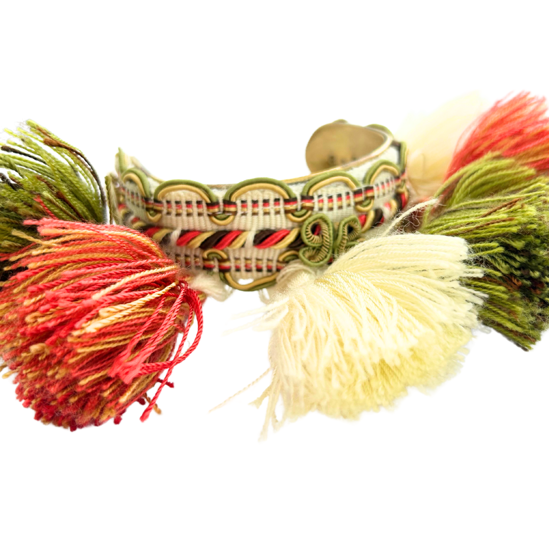 Olive tassel cuff bracelet – 1-inch brass cuff wrapped in vintage trim with oversized tassels in coral, ivory, and olive, designed for playful maximalist style.