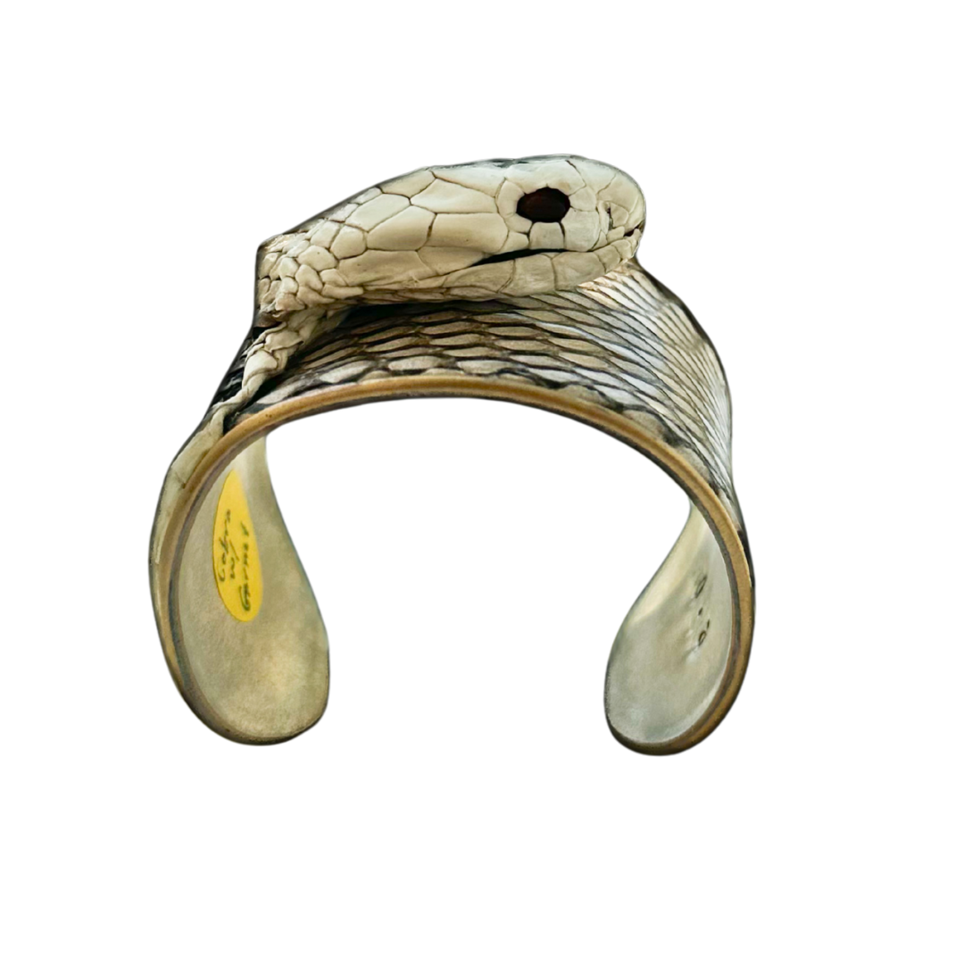 side view of cobra snake skin cuff bracelet with ivory and taupe scales, sculpted snake head, and polished brass interior; one-of-a-kind luxury jewelry.