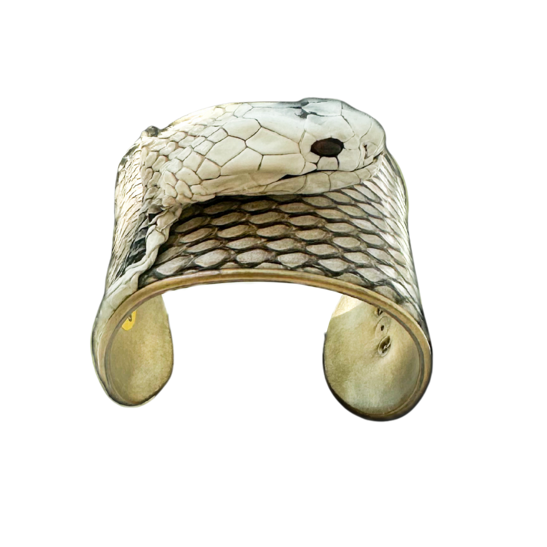 Side angle of statement cuff bracelet with detailed cobra scales, warm brass lining, and garnet gemstone eyes; snake skin jewelry from Redd Dott × The Wild Ones.