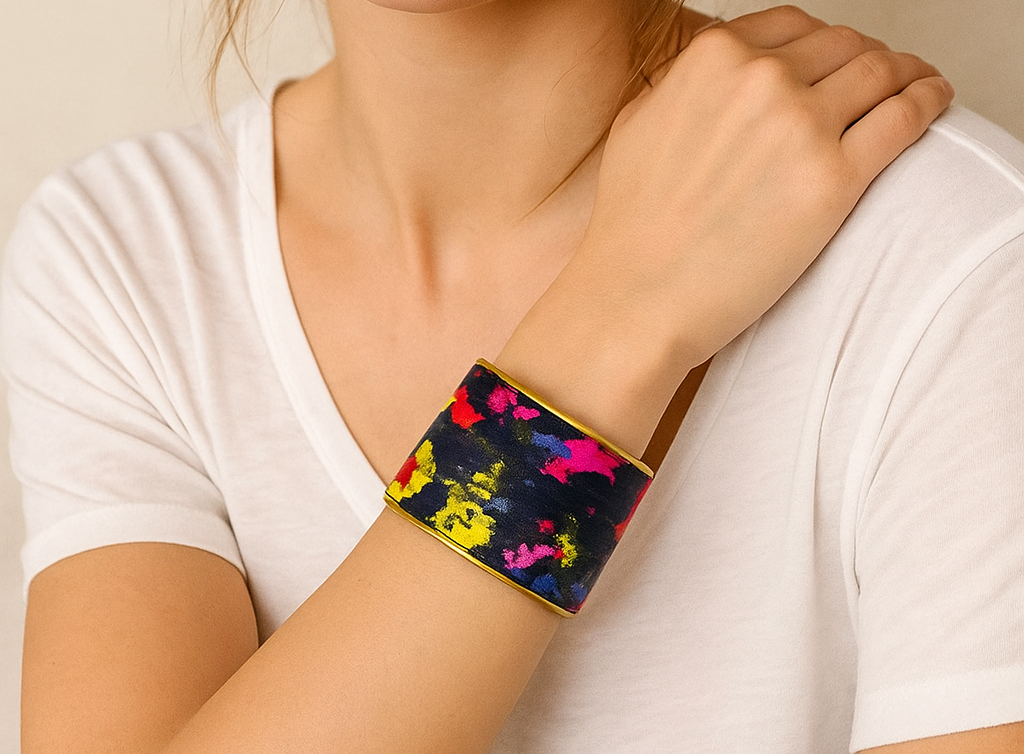 Woman wearing the Aura Custom Stamped Brass Cuff Bracelet featuring abstract multicolor fabric and golden brass edges — handcrafted in Shreveport, LA by Redd Dott Jewelry.