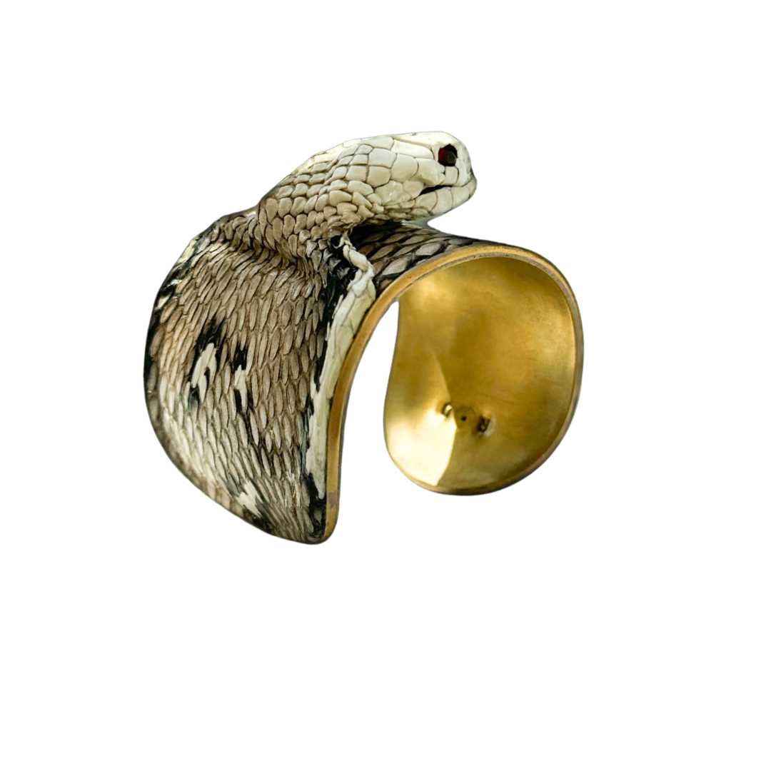 2-inch gold cuff bracelet wrapped in genuine ivory cobra snakeskin with sculpted serpent head and deep red garnet eyes; handcrafted exotic jewelry by Redd Dott.