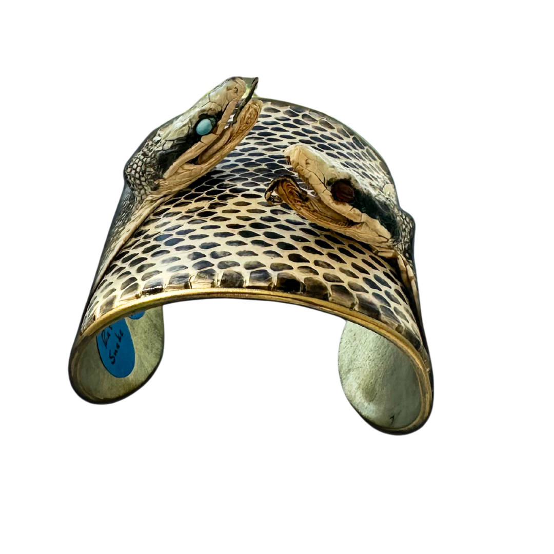 3-inch brass cuff bracelet handcrafted with genuine Texas rat snake skin featuring two real snake heads with garnet and turquoise eyes; one of a kind statement jewelry by Redd Dott.